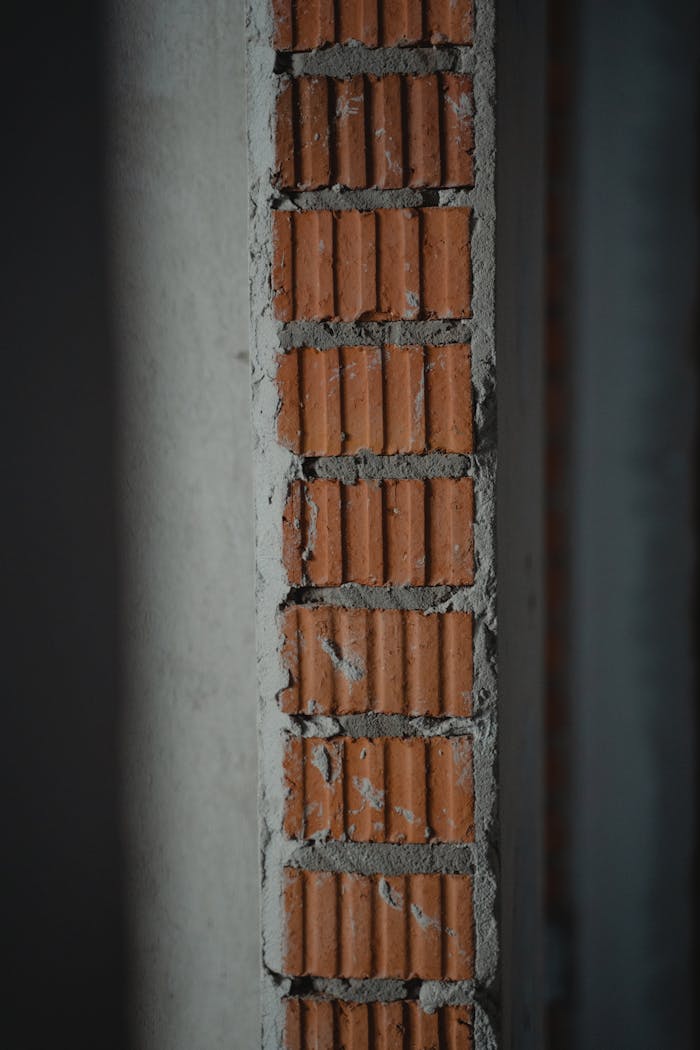 Detailed view of a brick and cement wall section, showing texture and workmanship.